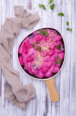 Krema soslu Gnocchi, ahşap arka planda pazı yaprakları ve sapları. Üst görünüm.