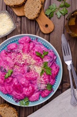 Krema soslu Gnocchi, ahşap arka planda pazı yaprakları ve sapları. Üst görünüm.