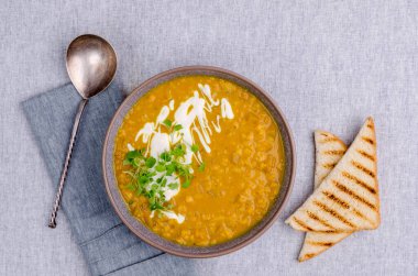 Tekstil arka planında mercimek ve sebzeli kalın çorba. Seçici odak.