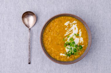 Tekstil arka planında mercimek ve sebzeli kalın çorba. Seçici odak.