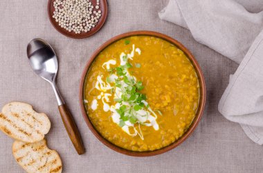 Tekstil arka planında mercimek ve sebzeli kalın çorba. Seçici odak.