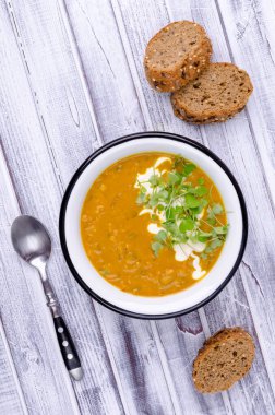 Ahşap arka planda mercimek ve sebzeli kalın çorba. Seçici odak.