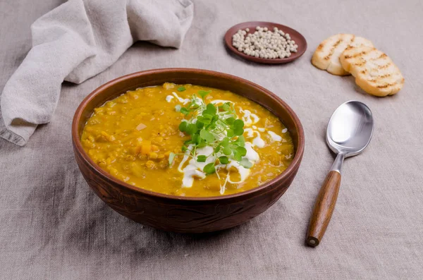 Tekstil arka planında mercimek ve sebzeli kalın çorba. Seçici odak.