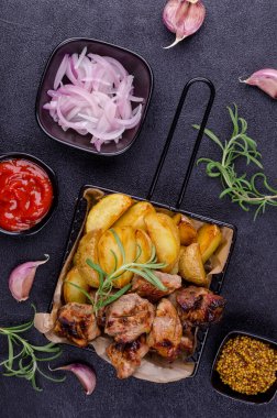 Siyah taşlı arka planda sebzeli kızarmış et dilimleri. Seçici odak.