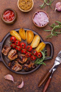 Eski metal bir arka planda sebzeli ve baharatlı kızarmış et dilimleri. Seçici odak.