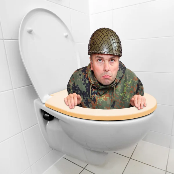 Cowardly soldier hiding in the toilet bowl — Stock Photo, Image