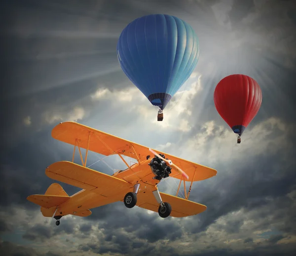 Biplane and hot air balloons — Stock Photo, Image