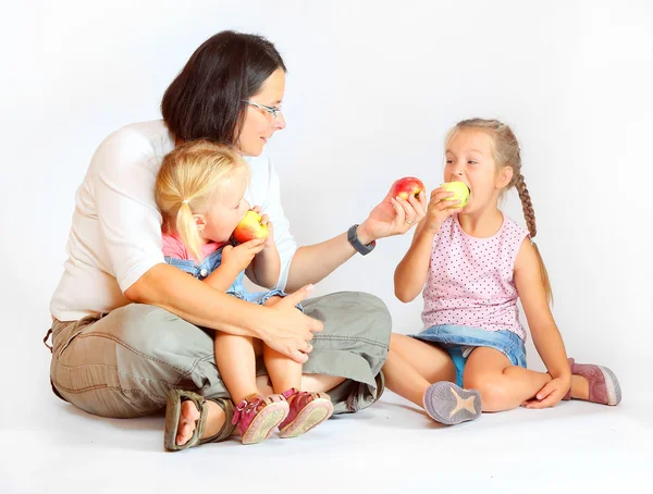 Família jovem comendo maçãs maduras frescas . — Fotografia de Stock