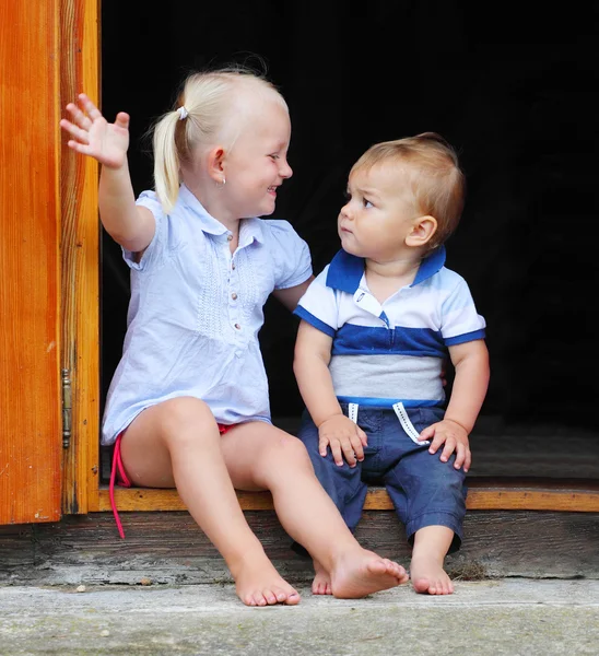 kırsal bir evin kapı aralığında oynayan çocuklar.