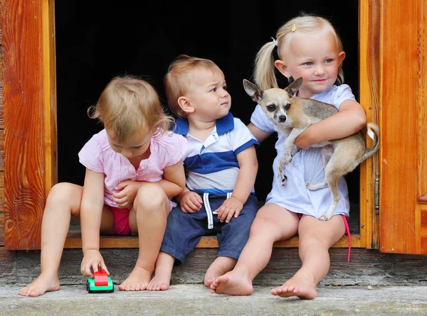 Dzieci gry w drzwiach do wiejskiej rezydencji. — Zdjęcie stockowe