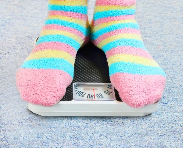Overweight woman on a retro style weighing machine — Stock Photo, Image