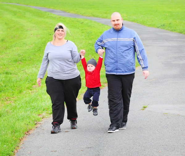 Obézní rodiče se svým synem běží společně. — Stock fotografie
