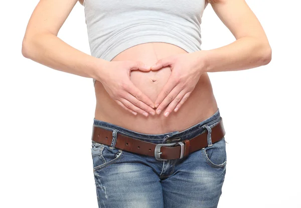 As mãos de uma mulher formando um símbolo de coração na barriga — Fotografia de Stock