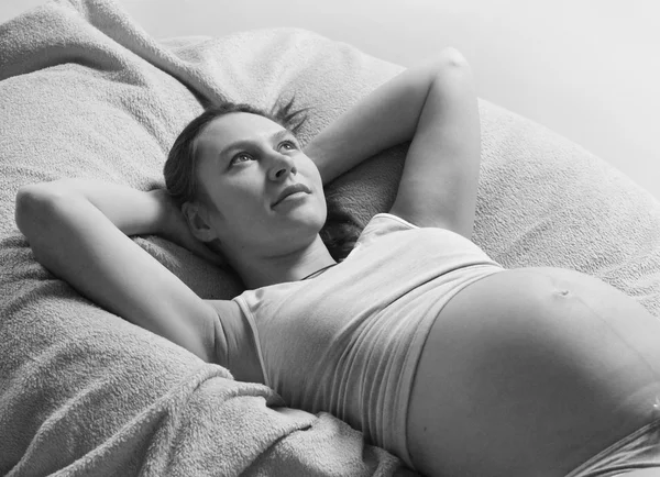 Беременная женщина лежит на кровати — стоковое фото