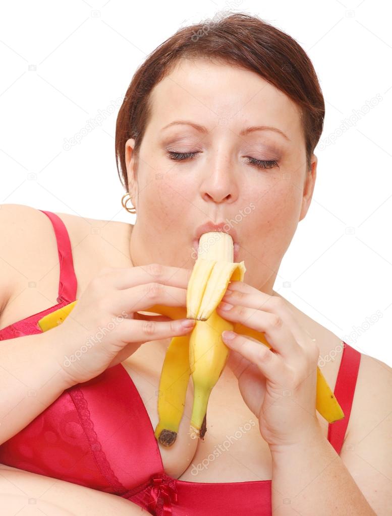 Overweight woman eating sweet banana. 