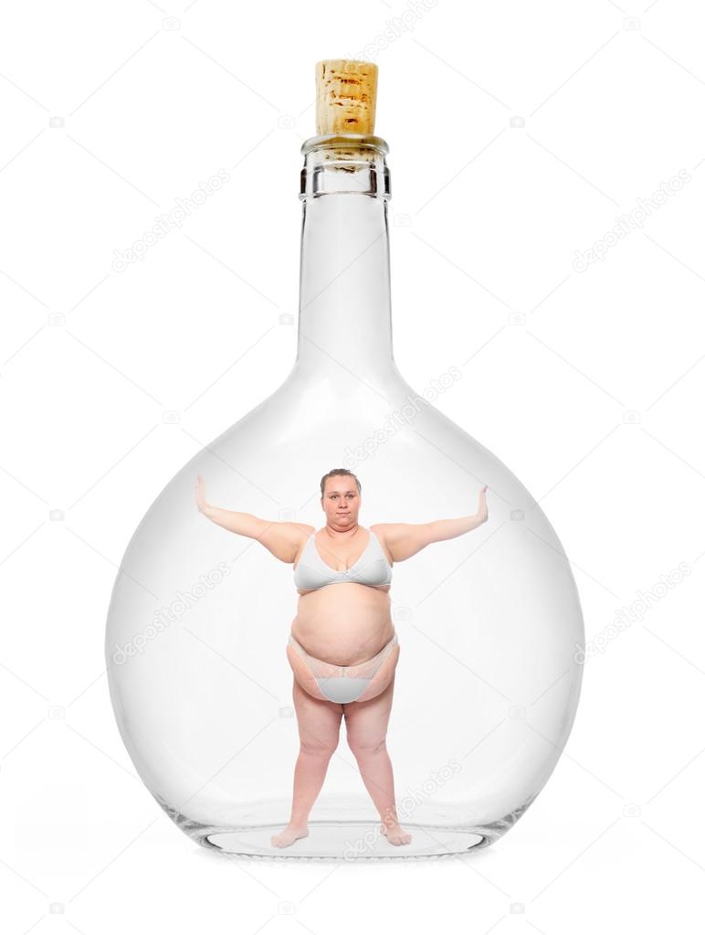 Overweight woman closed in a glass bottle