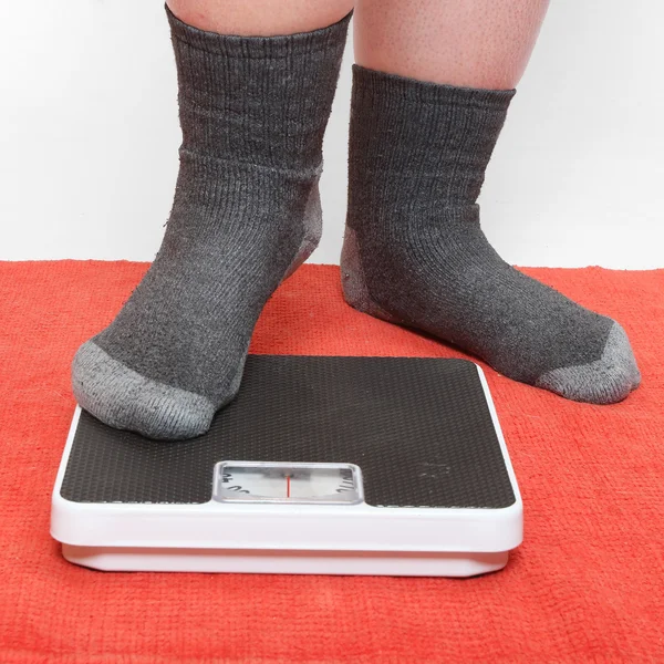 Overweight woman on a retro style weighing machine — Stock Photo, Image