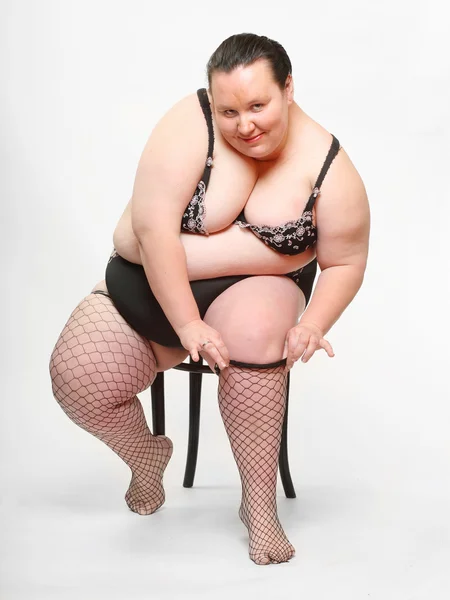 Overweight woman striping down her stockings — Stock Photo, Image