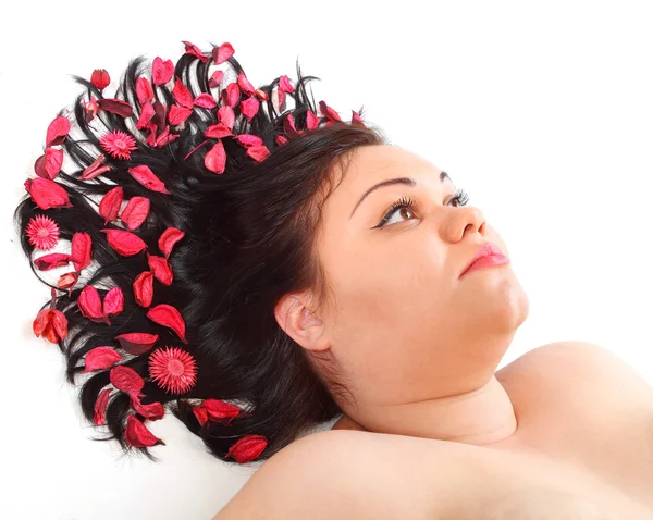 Overweight woman relaxing with petals in hair — Stock Photo, Image