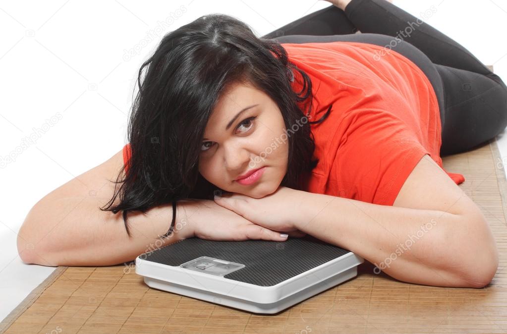 Overweight woman with weighing machine