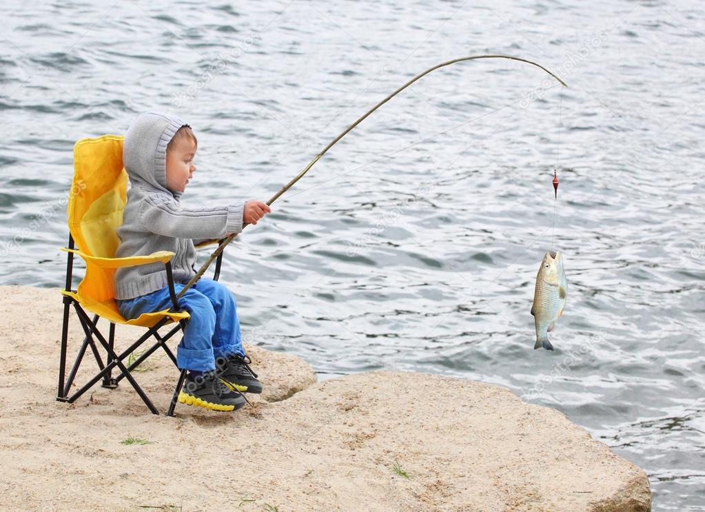 Little boy catching a fish — Stock Photo © vladvitek #65989293