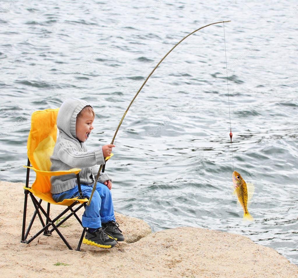 Little boy catching a fish — Stock Photo © vladvitek #65989315