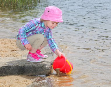 Küçük kız kova ve spade ile oynama