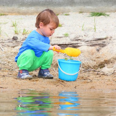 Küçük çocuk kova ve spade ile oynama