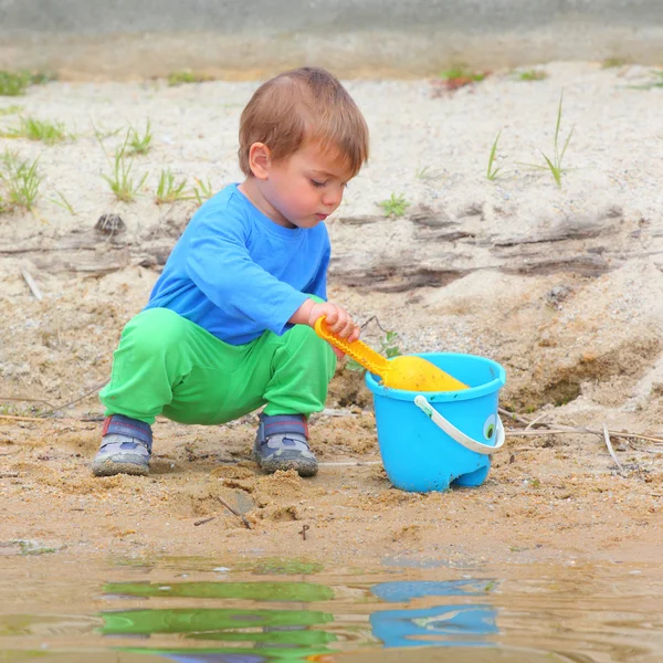 Niño jugando con cubo y pala —  Fotos de Stock