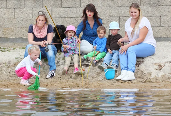 Young mothers with her kids catching a fish — Stock Photo, Image