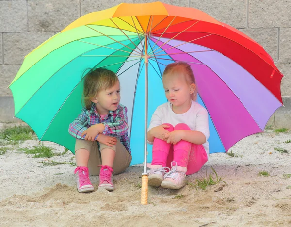 Kleine Kinder mit Sonnenschirm am Strand. — Stockfoto