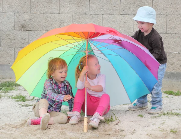 Little kids with umbrella on the beach. — Stock Photo, Image