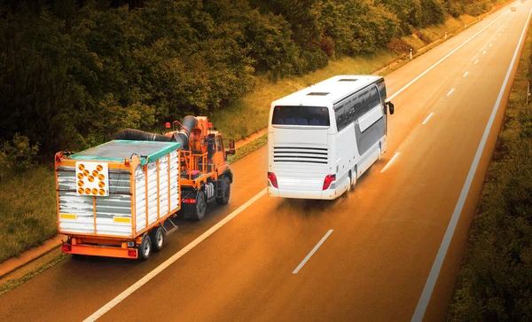 Langzame vrachtwagen en snelle bus — Stockfoto