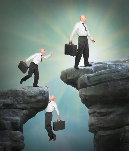 Businessmen climbing on a cliff — Stock Photo, Image