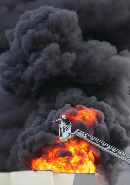 Пожарный и горящий дом . — стоковое фото