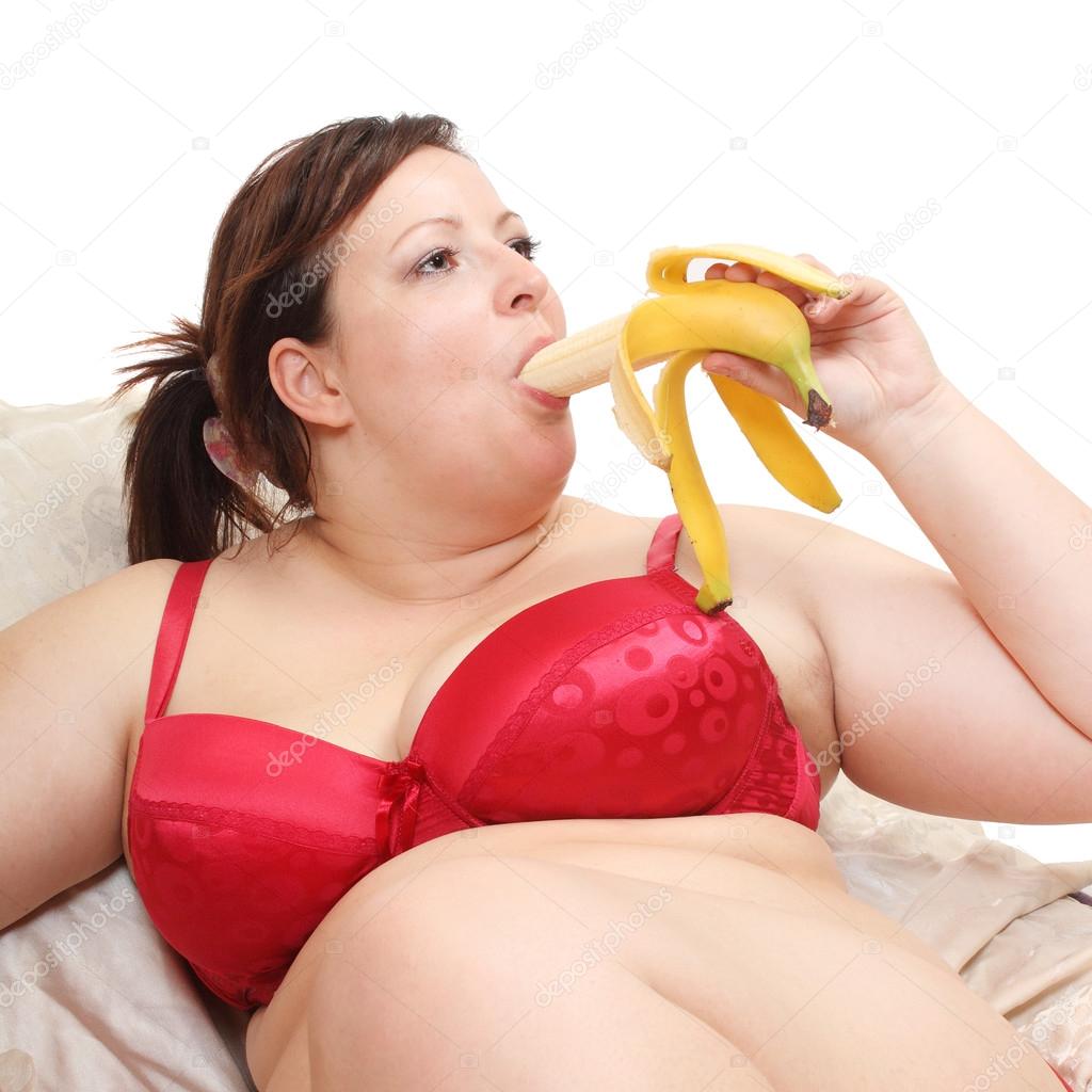 Overweight woman eating sweet banana.