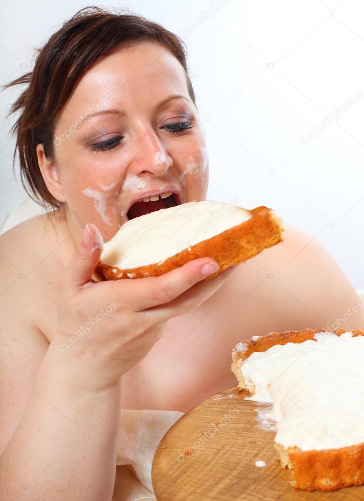 Overweight woman eating sweet cake