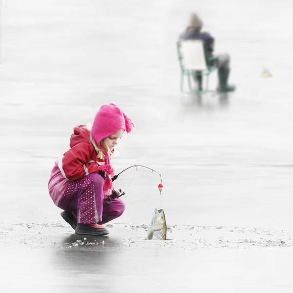 Kleine kind vissen op een bevroren meer in de winter. — Stockfoto