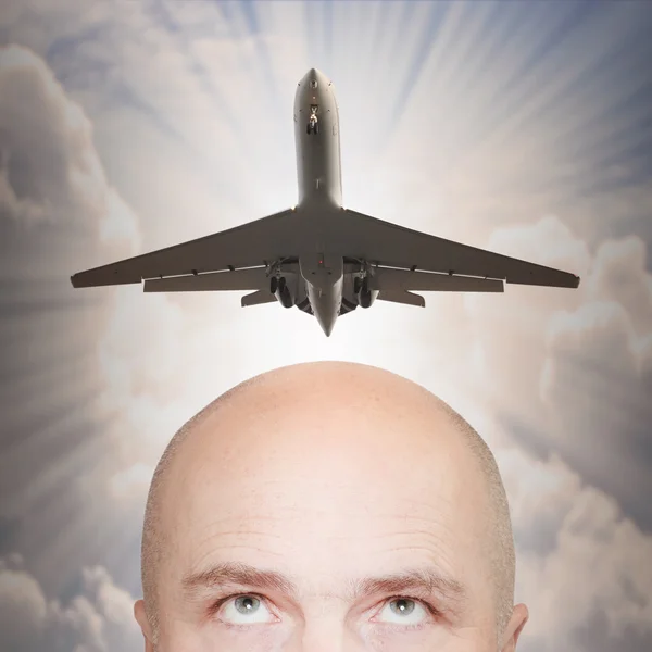 Hombre y avión de pasajeros sobre su cabeza . — Foto de Stock
