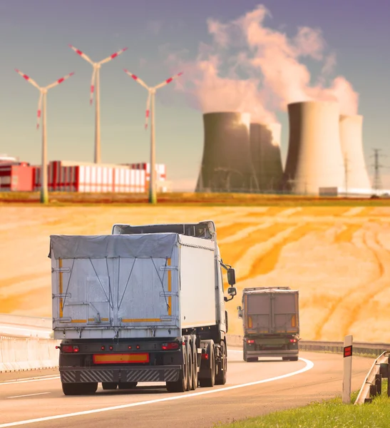 Vrachtwagens op de snelweg in industrieel landschap — Stockfoto