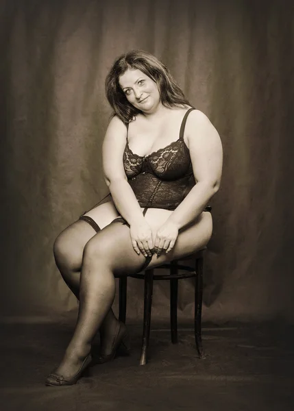 Overweight woman dressed in corset and nylons — Stock Photo, Image