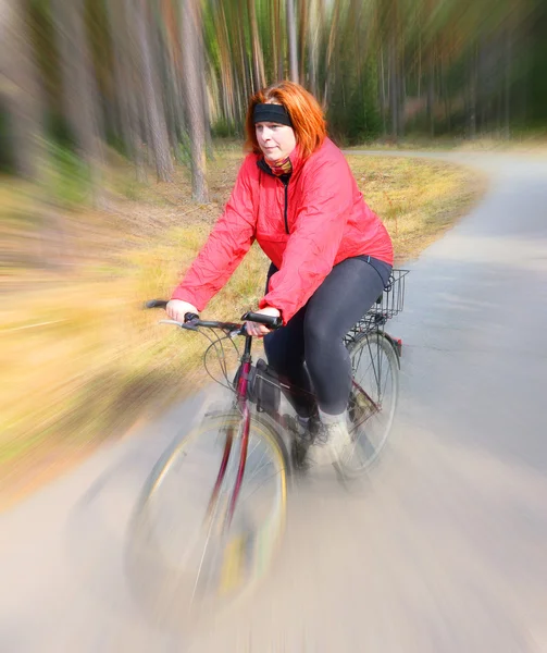 Overweight woman slimming on bicycle. — Stock Photo, Image