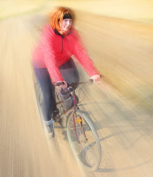 Overweight woman slimming on bicycle. — Stock fotografie