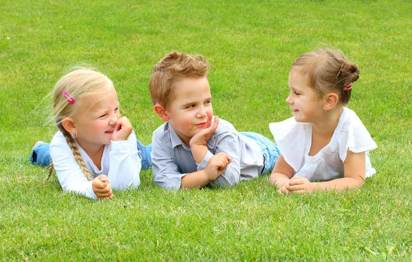三个小朋友在草地上有一个有趣的 — 图库照片