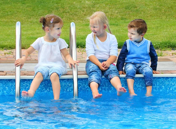 Three little friends have a fun in swimming pool. — Stock Photo, Image