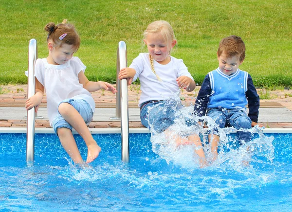 Tre piccoli amici si divertono in piscina . — Foto Stock