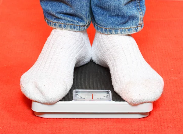 man standing on a retro style weighing machine