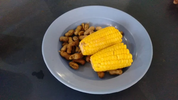 Boiled corn and peanuts on a plastic plate