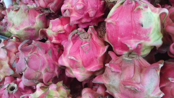 The pink fruit, commonly called dragon fruit, is widely sold in the market