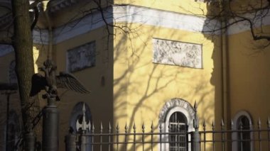 Rus Ortodoks Katedrali 'nin manzarası. Baharda yapraksız ağaçların arasından. Güneşli bir günde, aşağıdan kubbelere, saatli ve parlak haçlarla.